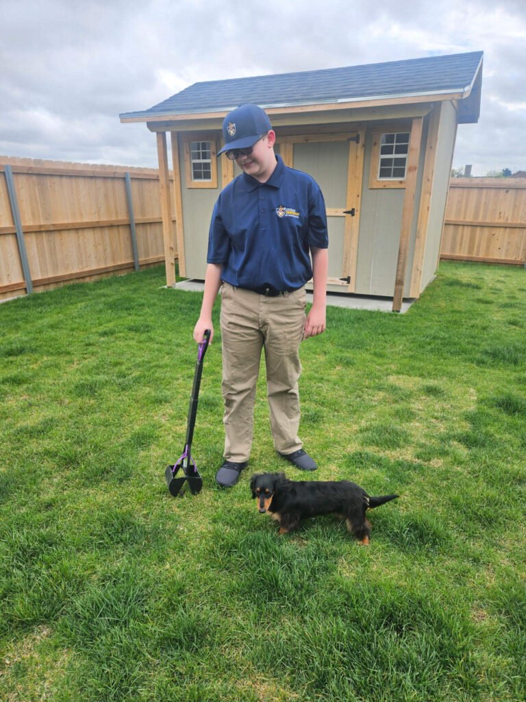 Dookie Dispatch worker in backyard with small dog.